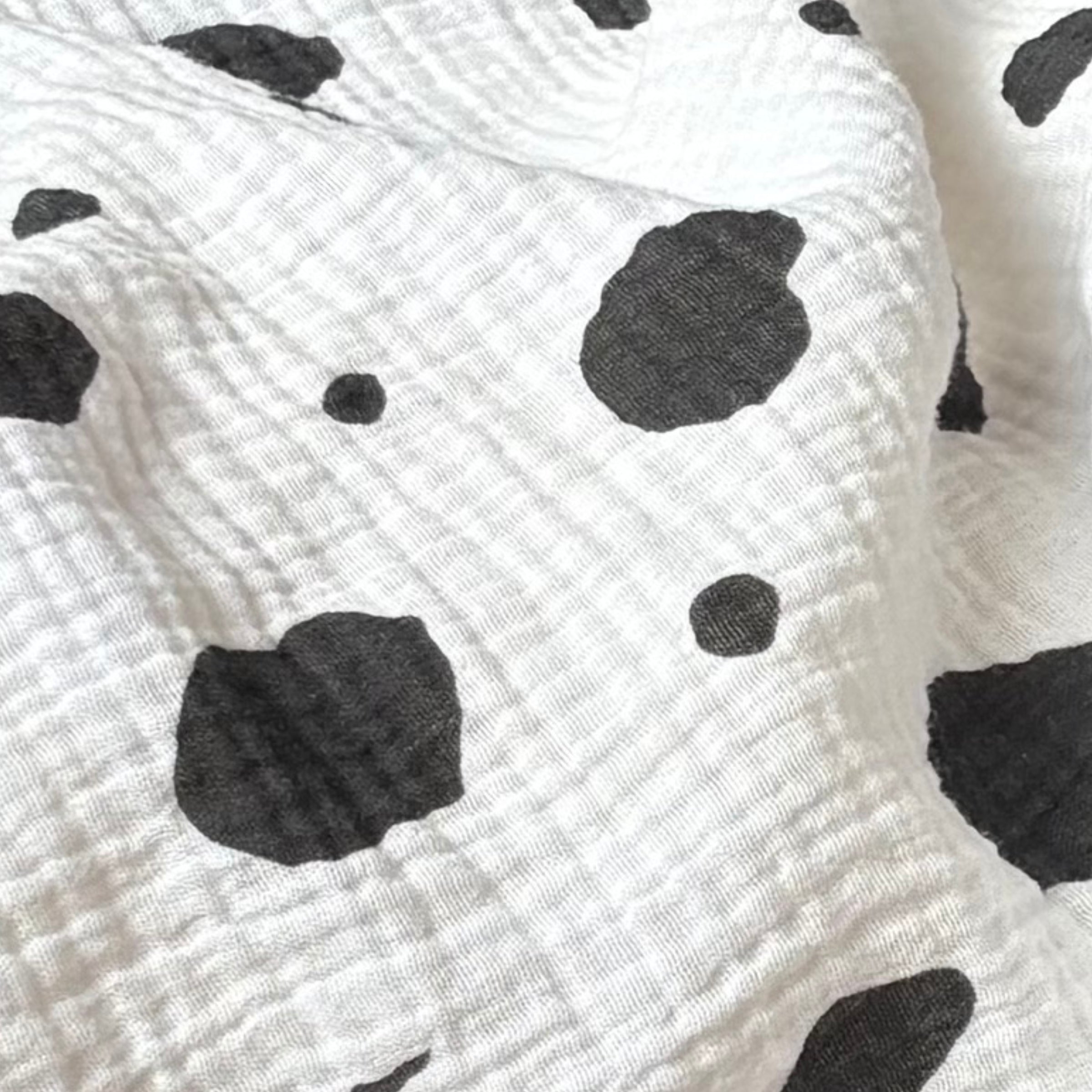 Close‑up view of the Small Square Allure en Noir muslin fabric highlighting breathable cotton texture and spotted pattern.