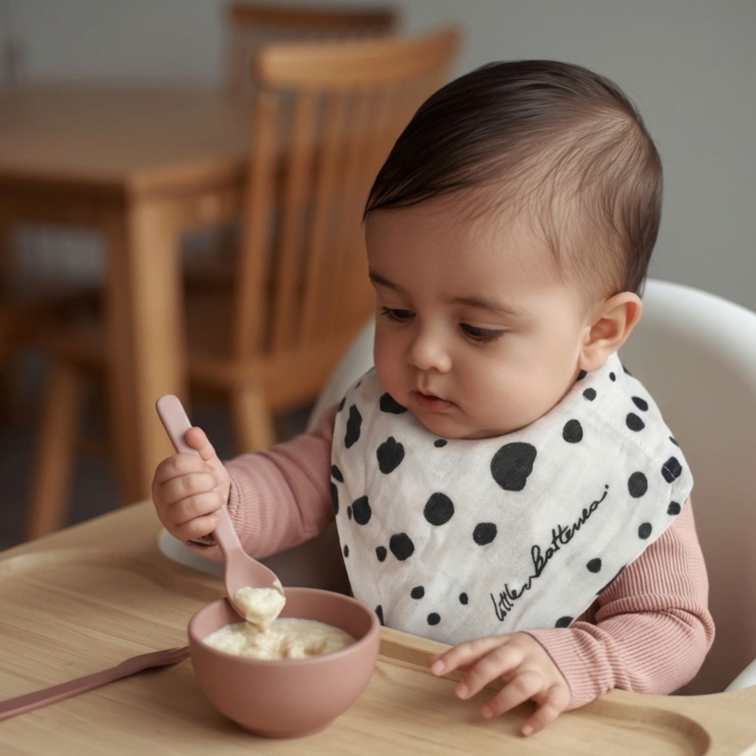 The Small Square muslin used during feeding time, worn as a bib to show practical everyday use.