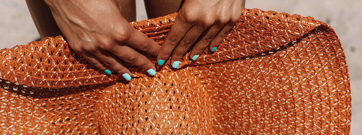 Close-up of a person's hands holding a woven bag with a blurred background