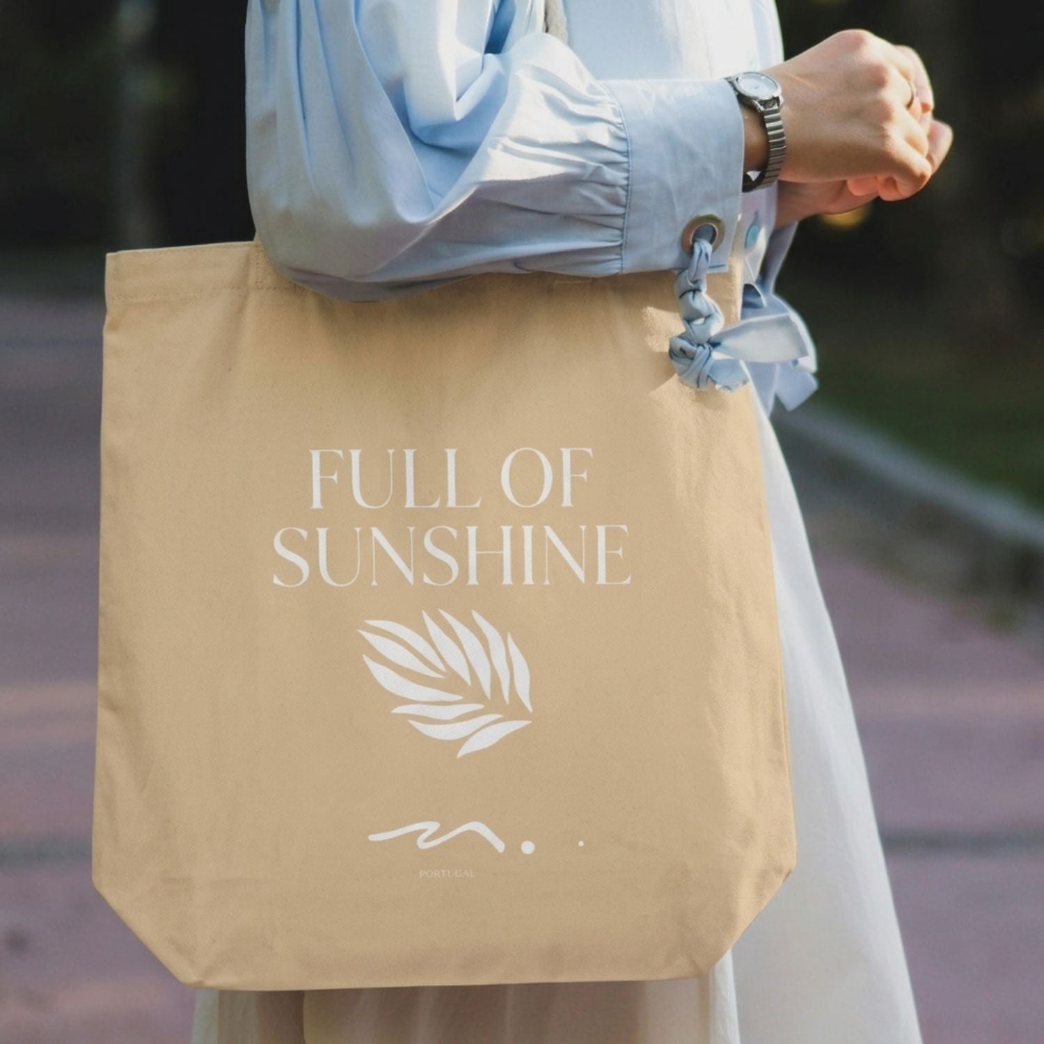 Carry All tote bag with 'Full of Sunshine' text held by a person outdoors.