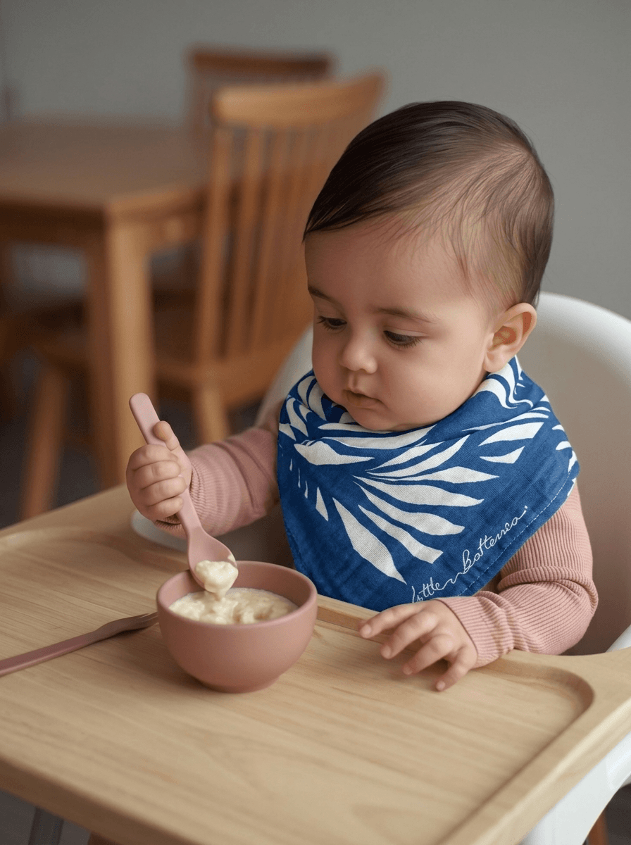 Child eating from a bowl with a blue bib in a home setting
