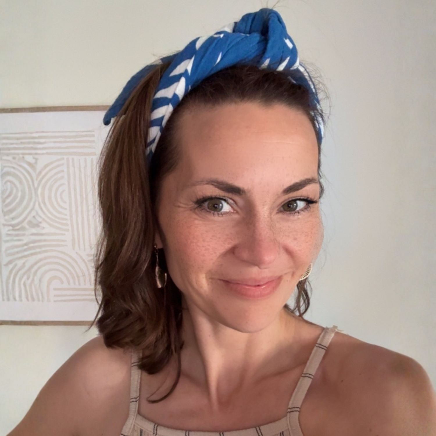The Azul Tropique Small Square worn as a headscarf, showing styling and use beyond the newborn phase.